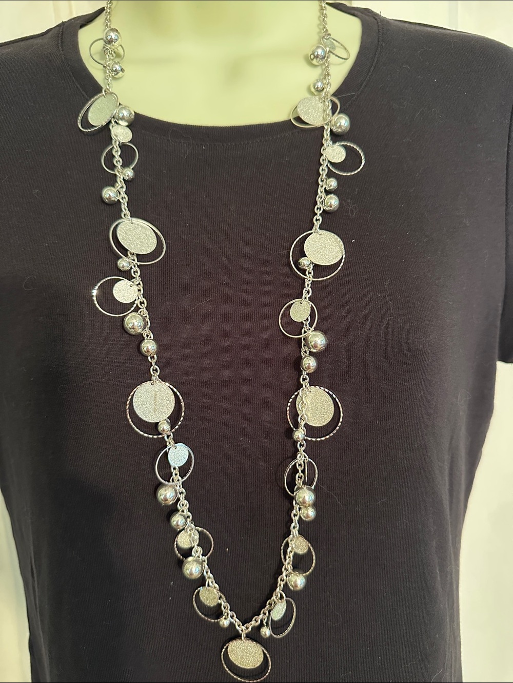Long Shiny silver tone necklace with open circles, solid discs,‎ & accent beads.